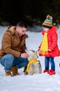 Happy father with daughter on a walk in the woods, girl and husky in yellow scarves, bright clothes in winter Royalty Free Stock Photo