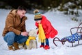 Happy father with daughter on a walk in the woods, girl and husky in yellow scarves, bright clothes in winter Royalty Free Stock Photo