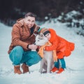 Happy father with daughter on a walk in the woods, girl and husky in yellow scarves, bright clothes in winter Royalty Free Stock Photo