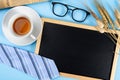 Happy Father Day background concept with blue necktie glasses, newspaper, dry grass flower, cup of tea and blackboard on blue