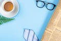 Happy Father Day background concept with blue necktie, glasses, newspaper, leaf and cup of tea on blue background with copy space