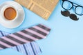 Happy Father Day background concept with blue and pink necktie, glasses, newspaper, cup of tea and black mustache on blue