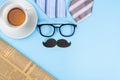 Happy Father Day background concept with blue and pink necktie, glasses, newspaper, cup of tea and black mustache on blue