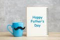 Happy Father day with paper notepad, Blue coffee cup or tea mug and Black mustache decor on table. International men day and Royalty Free Stock Photo