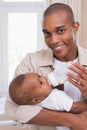Happy father feeding his baby boy a bottle Royalty Free Stock Photo