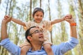 Happy father giving daughter piggyback ride on his shoulder in park Royalty Free Stock Photo