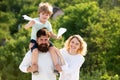 Happy father giving shoulder ride on his shoulders. Happy child showing his parents paper airplane. Happy family and Royalty Free Stock Photo
