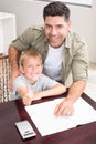 Happy father helping son with his math homework at table Royalty Free Stock Photo