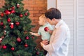 Happy father and his baby son decorating the Christmas tree at home. Royalty Free Stock Photo