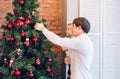 Happy father and his baby son decorating the Christmas tree at home. Royalty Free Stock Photo