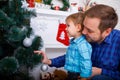 Happy father and his little son decorating the Christmas tree at home. Royalty Free Stock Photo