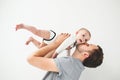 Happy father holding baby in hands over head isolated background