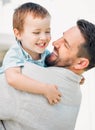 Happy father holding his excited son. Caucasian dad bonding with his son outside. Cheerful little boy being carried by Royalty Free Stock Photo