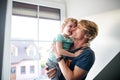 A happy father with a toddler son at home, kissing.