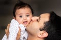 Happy father holds infant son in his arms and kisses Royalty Free Stock Photo