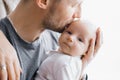 Happy father holds a newborn baby in his arms and kisses him Royalty Free Stock Photo