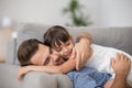 Happy father hugging cute child resting together on comfortable Royalty Free Stock Photo