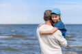 Happy father hugging his little daughter on the beach, father and daughter walking on the beach and posing to camera Royalty Free Stock Photo