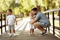 Happy father with joyful kids at the park, caring dad hug cute daughter, smiling, spend time together, enjoy family Royalty Free Stock Photo