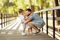 Happy father with joyful kids at the park, caring dad hug little daughter and cute son, smiling, spend time together