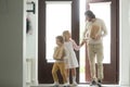 Smiling father with kids coming back home holding paper bags