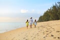 Happy father with kids have fun on beach walking at sunset