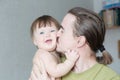Happy Father Kissing Baby Daughter Portrait. Happiness In Simple Lifestyle. Handsome Bearded Young Man Holding Infant