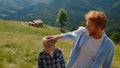 Happy father leading son by hand walking hill closeup. Man ruffling boy hair.