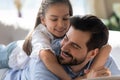 Happy father and little daughter hugging, lying on couch together Royalty Free Stock Photo