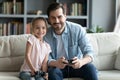 Happy father and little daughter playing video game at home Royalty Free Stock Photo