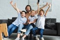 happy father and little sons sitting on sofa and playing video games together Royalty Free Stock Photo