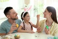 Happy father, mother and daughter having fun while painting Easter eggs at table Royalty Free Stock Photo
