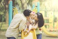 Father and mother kissing daughter on slides Royalty Free Stock Photo