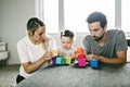 Happy father, mother and little daughter playing with toy blocks at home Royalty Free Stock Photo