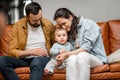 Happy father, mother and little son are playing on sofa in living room. Child care and parenting Royalty Free Stock Photo