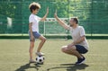 Happy father playing football on a field with son