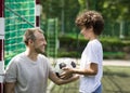 Happy father playing football on a grass with son Royalty Free Stock Photo