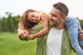 Happy father playing with his cute little daughter, holding her on his shoulders and smiling, daughter and daddy