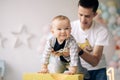 Happy father plays with his son celebrating first birthday of baby boy near colorful balloons Royalty Free Stock Photo