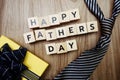 Happy Father`s Day alphabet letters with gift box on wooden background Royalty Free Stock Photo