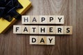 Happy Father`s Day alphabet letters with gift box on wooden background Royalty Free Stock Photo