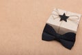 Happy Father`s Day Background. Beautiful retro style gift box and black bow tie on brown background. Fathers day.