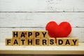 Happy Father`s Day concept with alphabet letters with red heart on space wooden background