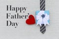 Happy Father`s day card idea, red hear with gift box on men necktie on canvas fabric texture background Royalty Free Stock Photo