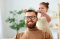 Happy father`s day! child daughter in crown does makeup to daddy Royalty Free Stock Photo