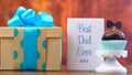 Father`s Day close up of gift, cupcake and card on wood background.