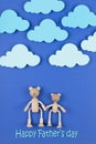 Happy Father`s Day concept. Greeting card with family of wooden toy bears on blue background. Royalty Free Stock Photo