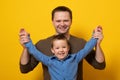 Happy father`s day! Cute father and son hugging on yellow background. Portrait of a dad with a baby boy smiling Royalty Free Stock Photo