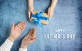 Happy father`s day.Gift in the hands of daughter and father on a blue background.I love you, dad.Love and health in the family. Royalty Free Stock Photo
