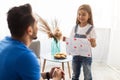 Happy little daughter greeting young dad with card Royalty Free Stock Photo